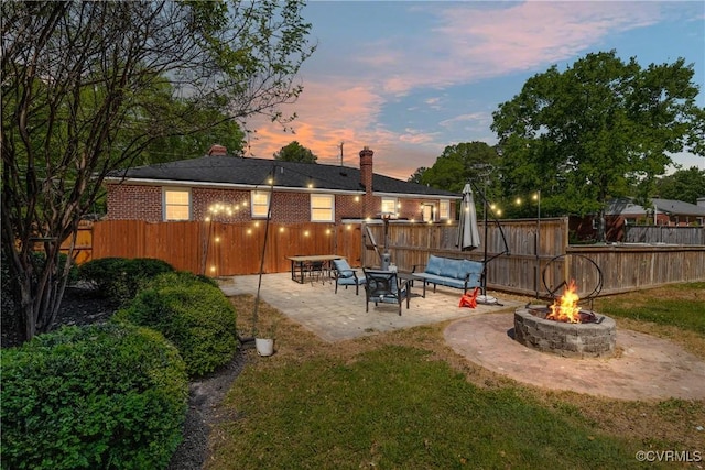 back of house featuring a chimney, fence private yard, a patio area, and an outdoor fire pit