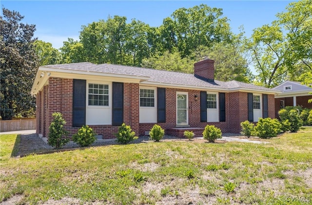 ranch-style house with fence, a chimney, a front lawn, and brick siding