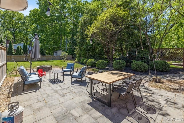 view of patio / terrace featuring a fenced backyard, outdoor dining area, and a fire pit