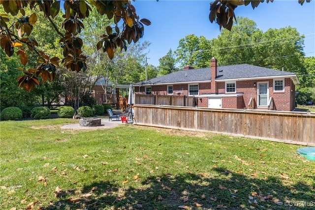 view of yard featuring fence, a fire pit, and a patio area