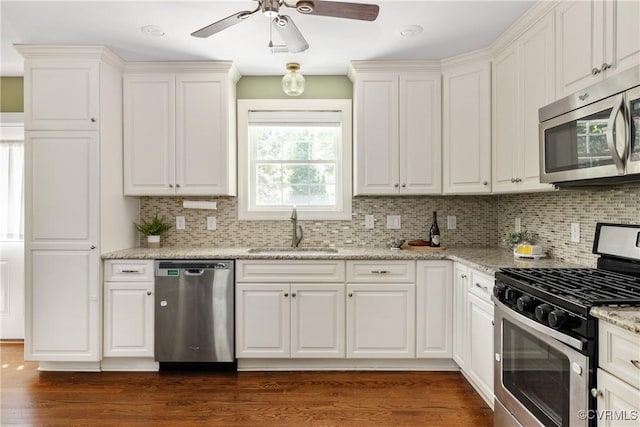 kitchen featuring a sink, appliances with stainless steel finishes, tasteful backsplash, and ceiling fan