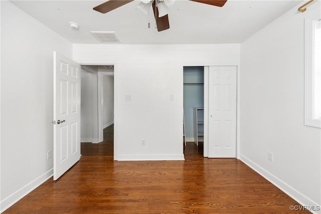 unfurnished bedroom with visible vents, baseboards, wood finished floors, and a closet