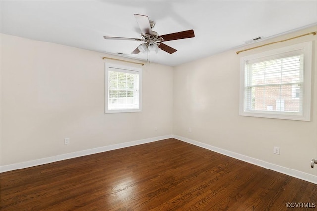 empty room featuring visible vents, baseboards, ceiling fan, and wood finished floors