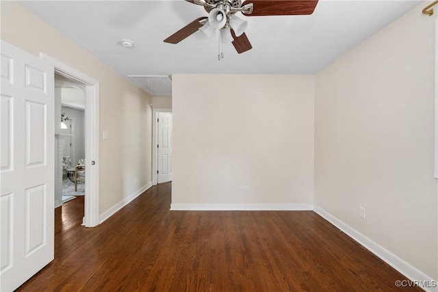empty room featuring baseboards, ceiling fan, attic access, and wood finished floors