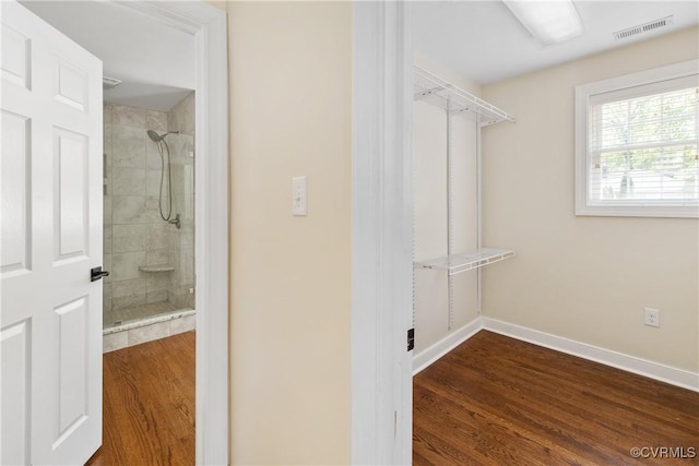 walk in closet with visible vents and dark wood-style flooring