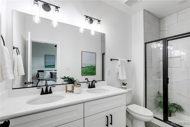 bathroom featuring toilet, visible vents, a shower stall, and a sink