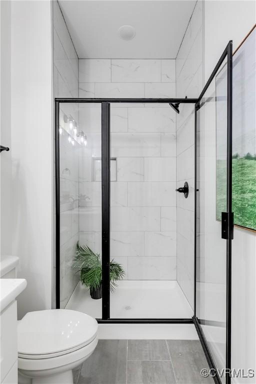 full bath with vanity, toilet, and a shower stall