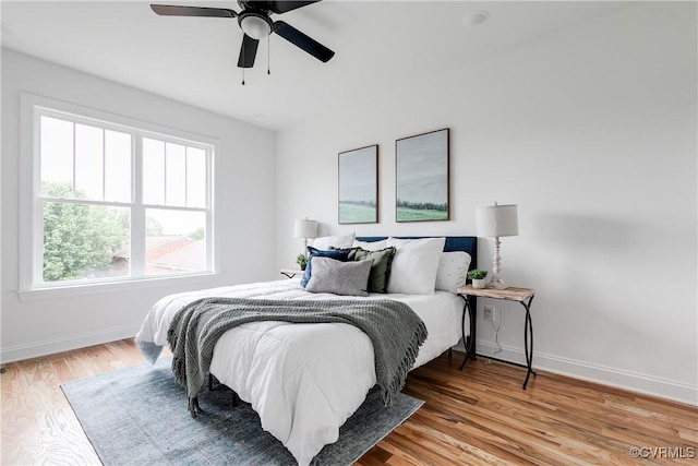 bedroom featuring baseboards, a ceiling fan, and wood finished floors
