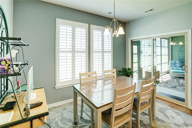 dining room with baseboards, a chandelier, and visible vents