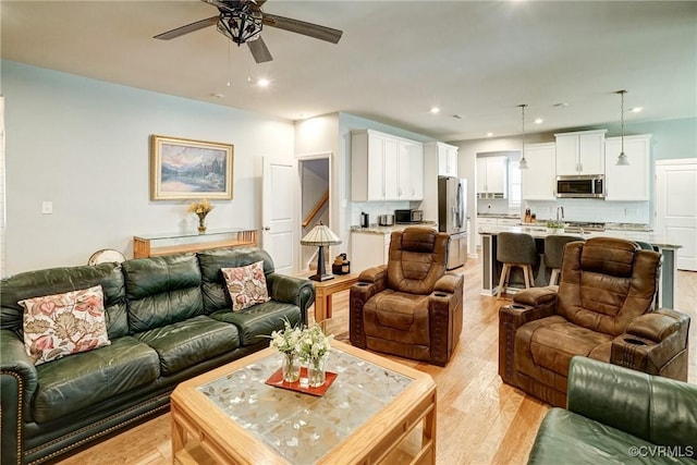 living area with recessed lighting, a ceiling fan, and light wood-style flooring