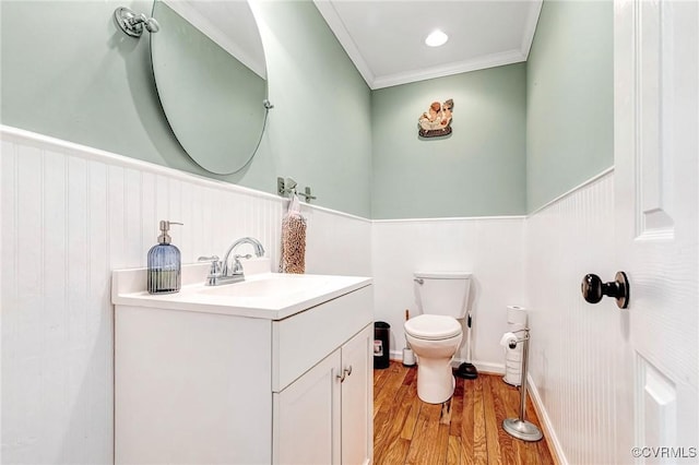bathroom with vanity, wainscoting, toilet, and wood finished floors