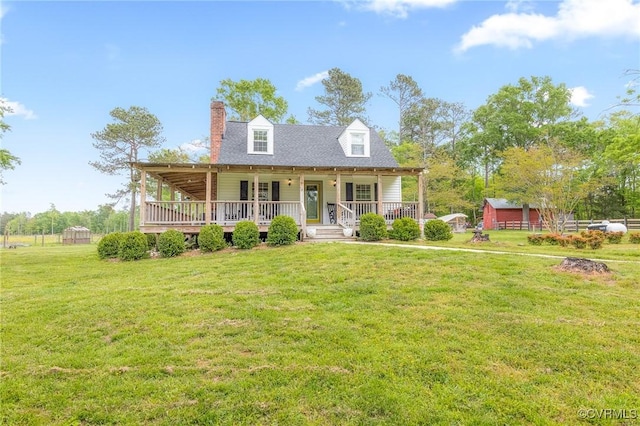 view of front facade featuring a front yard, a chimney, and covered porch