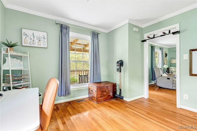 home office featuring baseboards, visible vents, ornamental molding, and light wood-type flooring