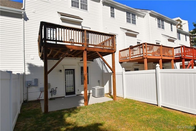 back of property with a wooden deck, a fenced backyard, cooling unit, a patio area, and a lawn