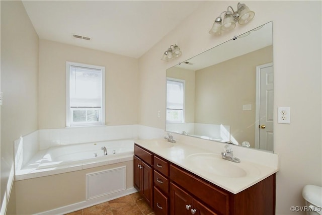 bathroom featuring visible vents, a sink, plenty of natural light, and a garden tub