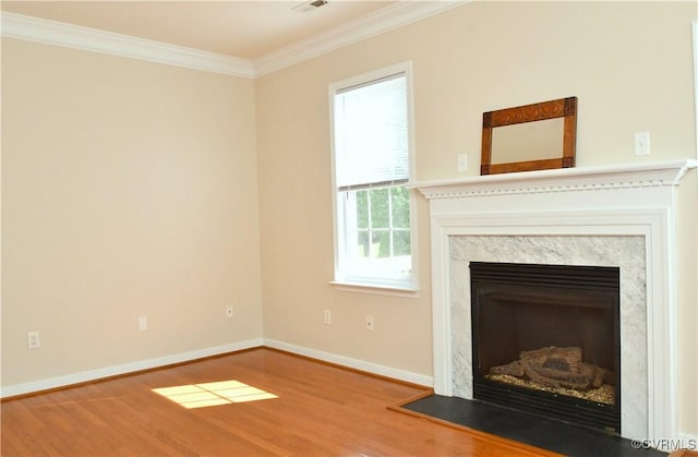 unfurnished living room featuring baseboards, ornamental molding, wood finished floors, and a fireplace