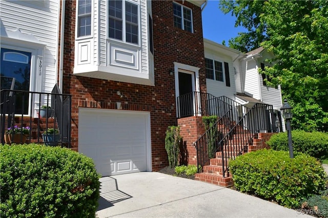 view of front of home with brick siding, a garage, and driveway