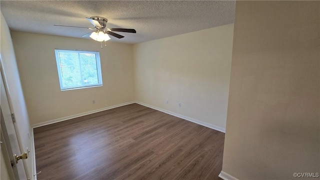 spare room with baseboards, a ceiling fan, dark wood-style floors, and a textured ceiling