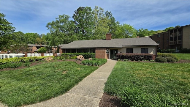 ranch-style house featuring a chimney and a front yard