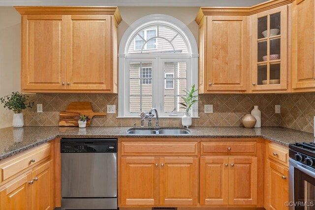 kitchen with dishwasher, a sink, range with gas stovetop, and glass insert cabinets