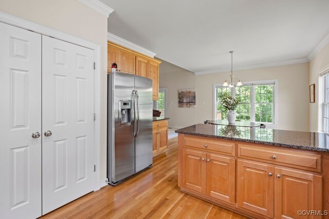 kitchen featuring stainless steel refrigerator with ice dispenser, ornamental molding, light wood-type flooring, stovetop, and dark stone counters
