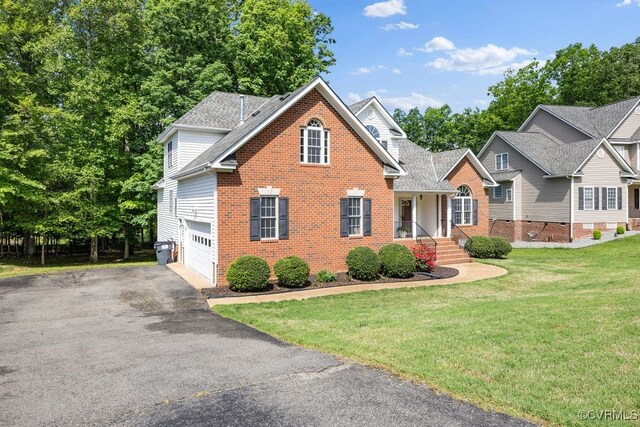 view of front of property featuring brick siding, driveway, a front lawn, a shingled roof, and an attached garage