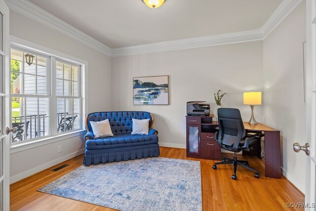 office space featuring healthy amount of natural light, crown molding, wood finished floors, and baseboards
