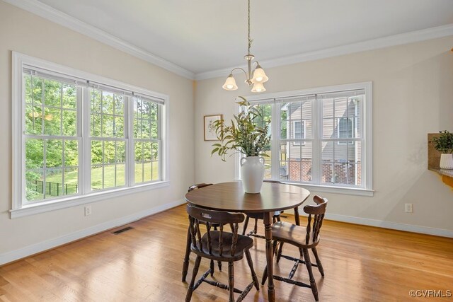 dining room featuring healthy amount of natural light, a chandelier, crown molding, and baseboards