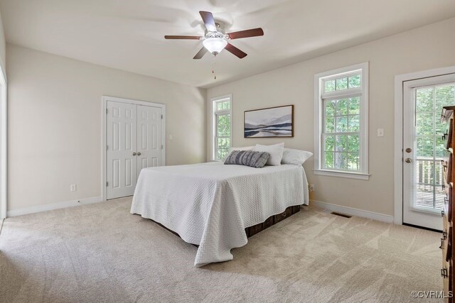 carpeted bedroom with baseboards, access to outside, ceiling fan, and a closet
