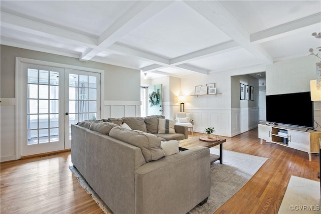living area featuring coffered ceiling, wainscoting, beam ceiling, wood finished floors, and a decorative wall