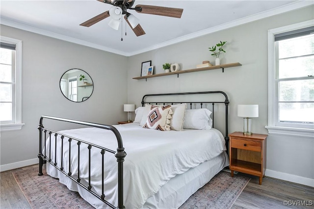 bedroom featuring baseboards, multiple windows, and wood finished floors