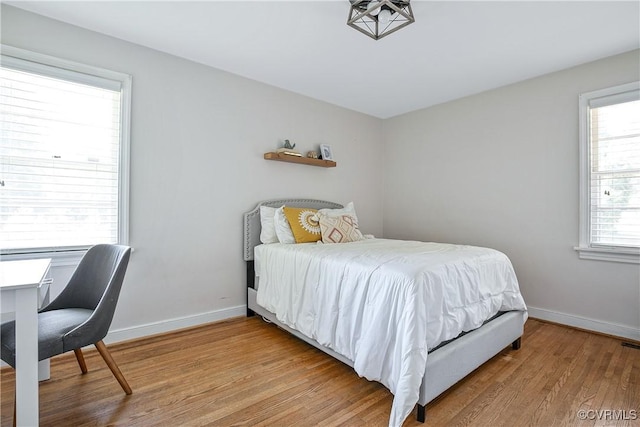 bedroom with baseboards and light wood finished floors