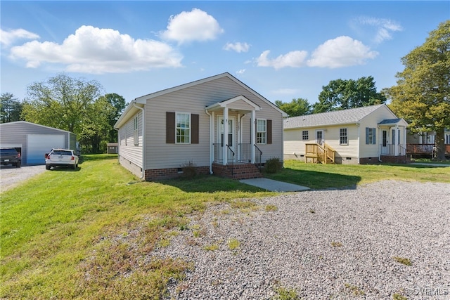 bungalow-style house featuring a detached garage, an outbuilding, a front yard, and crawl space