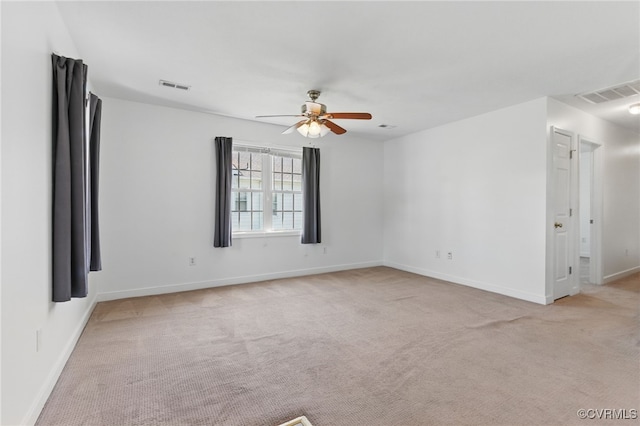 spare room featuring ceiling fan, visible vents, and light carpet