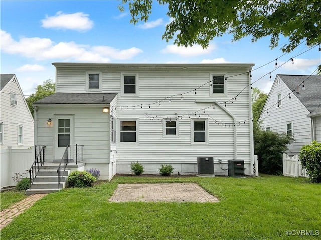 rear view of house featuring a lawn, a patio, fence, and central AC unit
