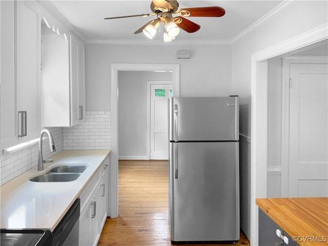kitchen with ceiling fan, white cabinets, tasteful backsplash, a sink, and stainless steel appliances