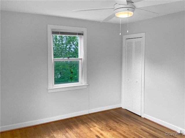 unfurnished room featuring baseboards, a ceiling fan, and wood finished floors