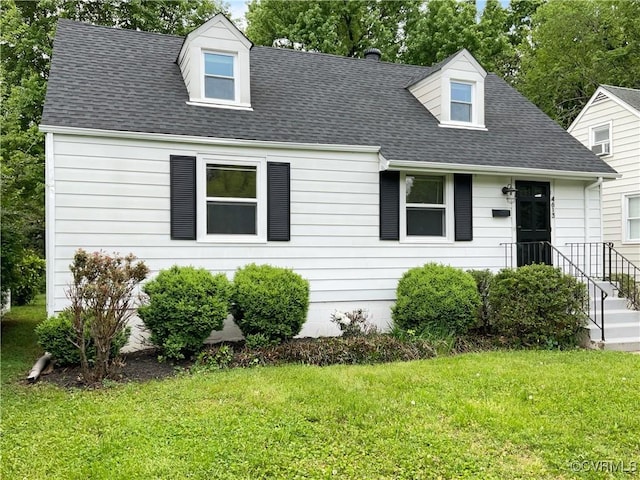 cape cod home with roof with shingles and a front yard