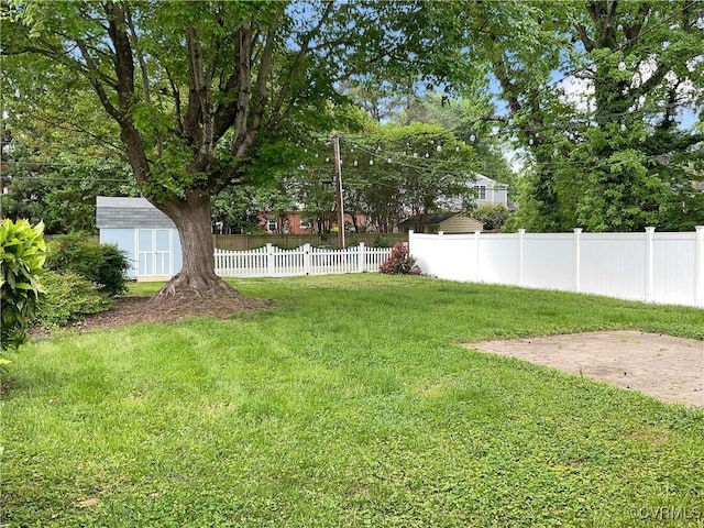view of yard featuring fence, an outdoor structure, and a shed