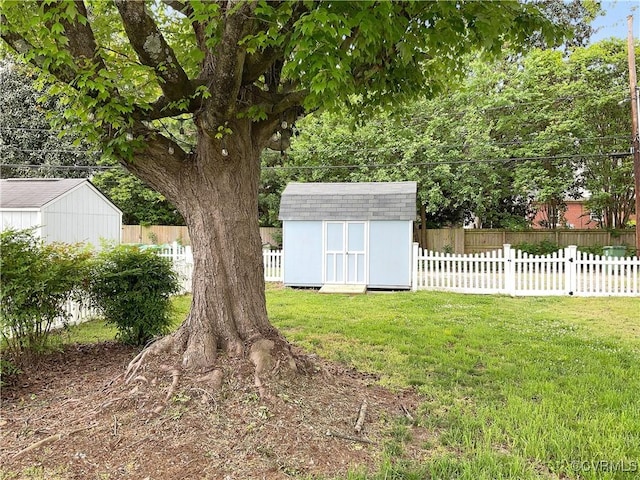view of yard featuring a storage shed, an outdoor structure, and a fenced backyard