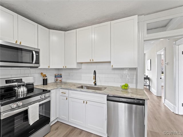 3105 2nd Ave, Richmond, VA 23222 - kitchen featuring white cabinetry, appliances with stainless steel finishes, a sink, and light wood finished floors