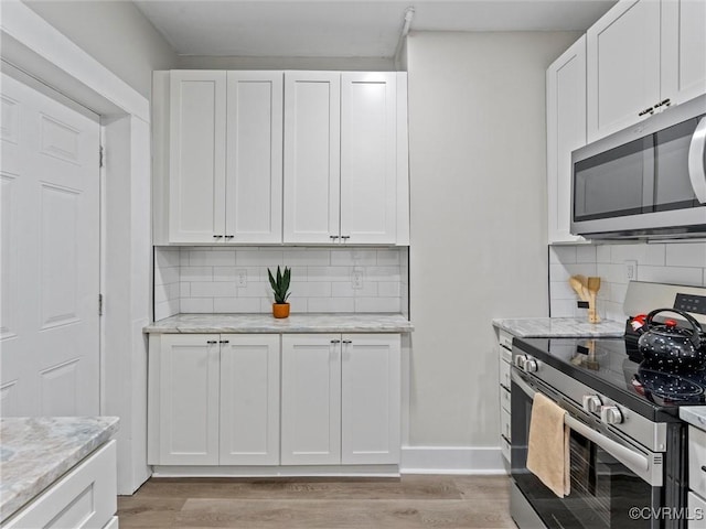 3105 2nd Ave, Richmond, VA 23222 - kitchen with white cabinetry, backsplash, and stainless steel appliances