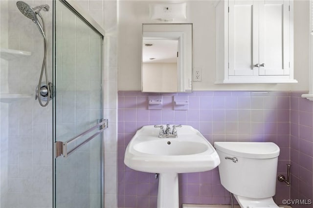 full bath featuring wainscoting, tile walls, a shower stall, and toilet