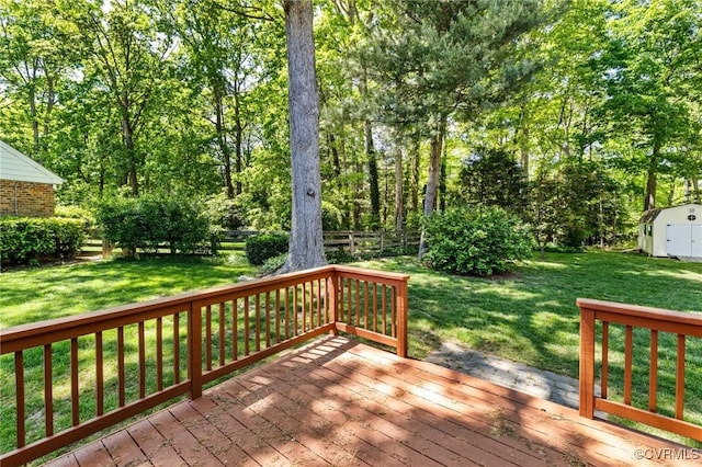 wooden terrace with a storage shed, a lawn, an outbuilding, and a fenced backyard