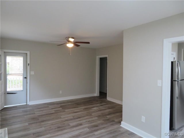 unfurnished living room with a ceiling fan, baseboards, and wood finished floors