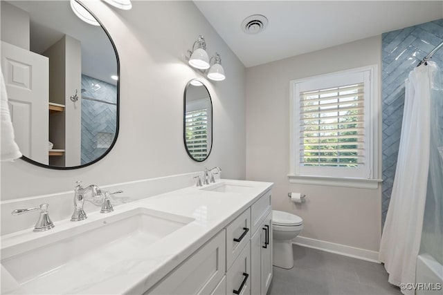 bathroom featuring a sink, baseboards, a wealth of natural light, and visible vents