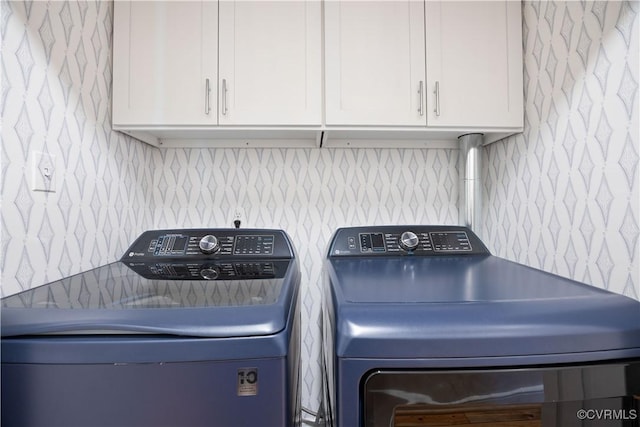 laundry room with cabinet space, washer and dryer, and wallpapered walls