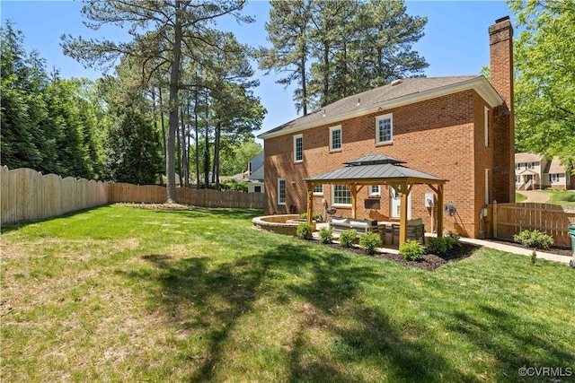 rear view of house featuring a gazebo, outdoor lounge area, a fenced backyard, a chimney, and a lawn