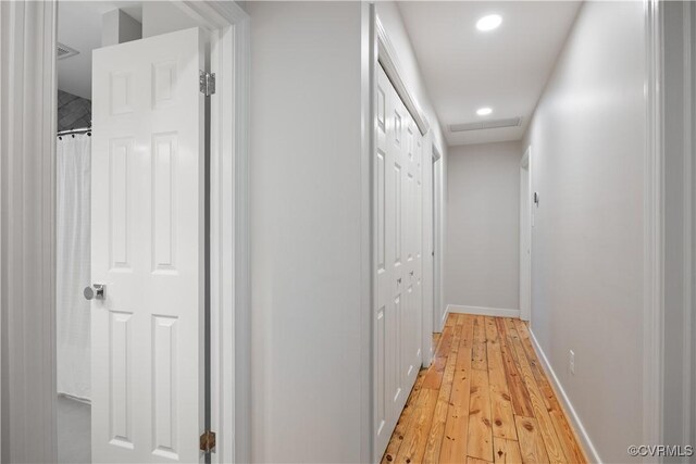 hallway featuring recessed lighting, baseboards, and light wood finished floors