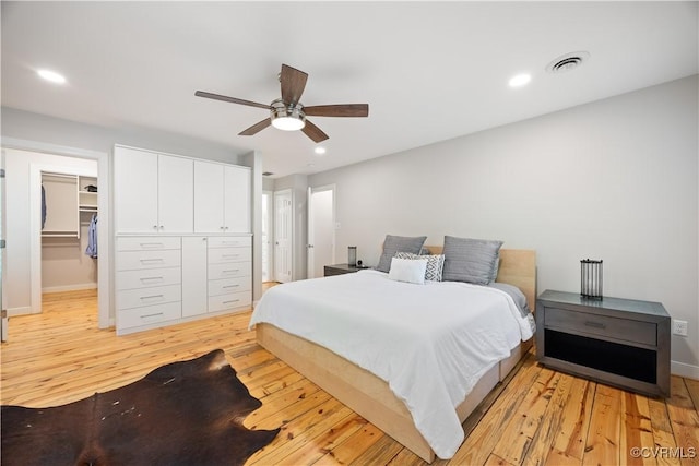bedroom with visible vents, light wood-type flooring, baseboards, a spacious closet, and recessed lighting